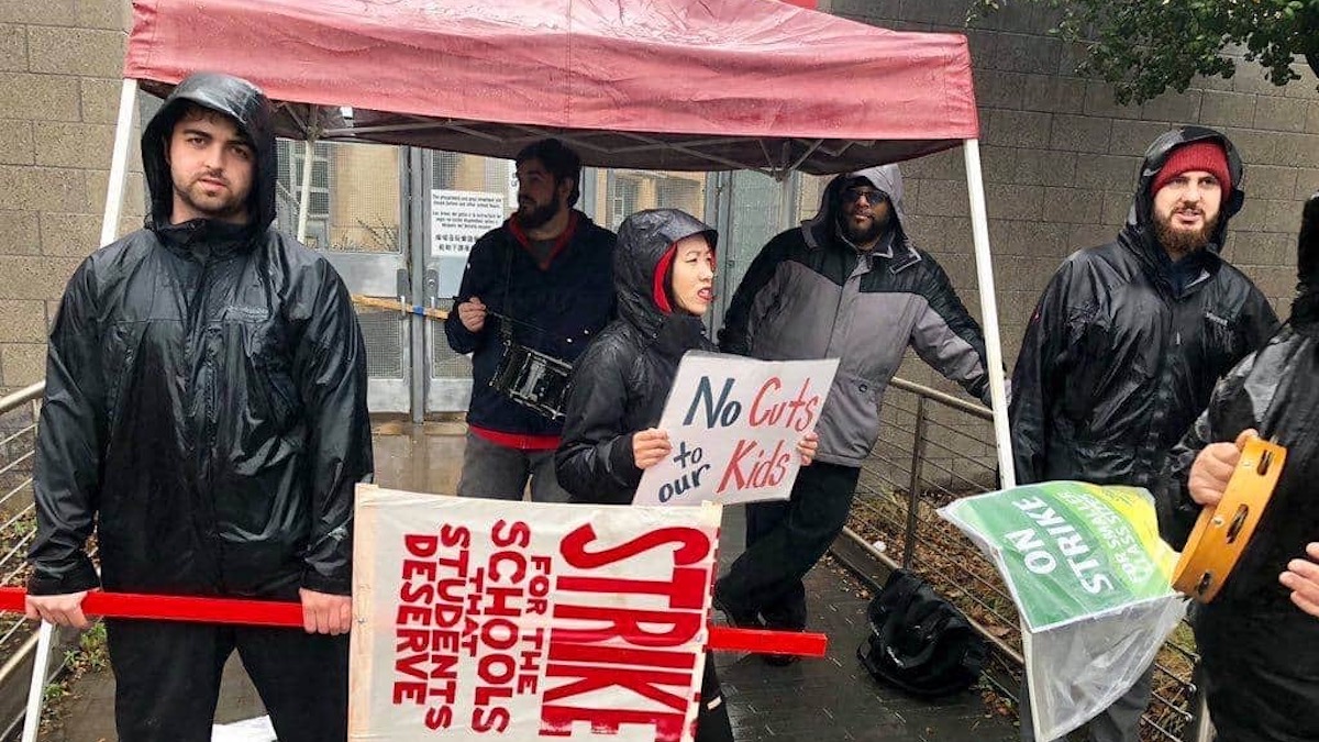 group of people standing in rain with signs