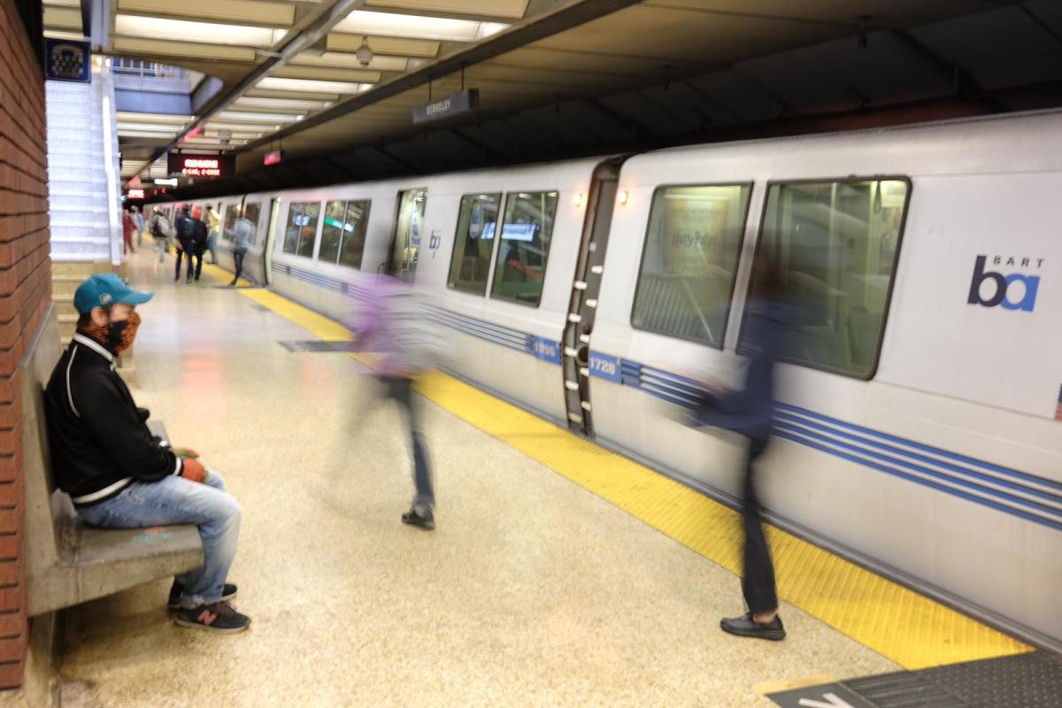A man sits on a bench as BART passengers exit a train after arriving in Downtown Berkeley. August 26, 2020. Photo- Pete Rosos