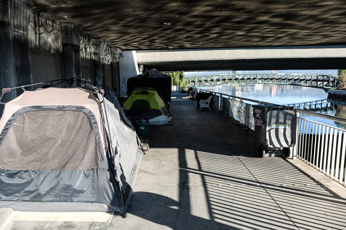 Tents under a bridge by Lake Merritt.