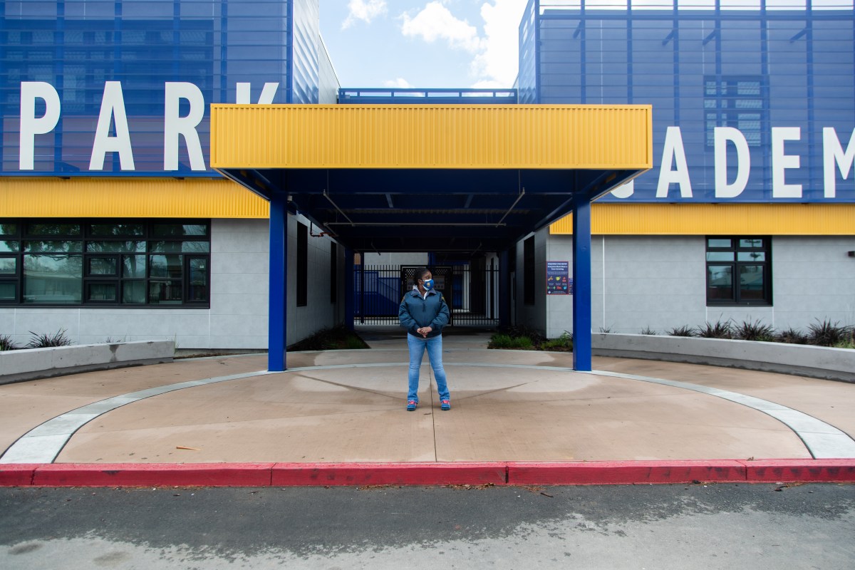 Tiffany Couch, security officer at Madison Park Academy stands in front of the newly constructed high school campus in Sobrante Park neighborhood, Oakland.