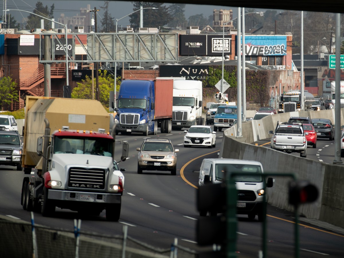 Semitrucks ride along Interstate 880 highway in East Oakland