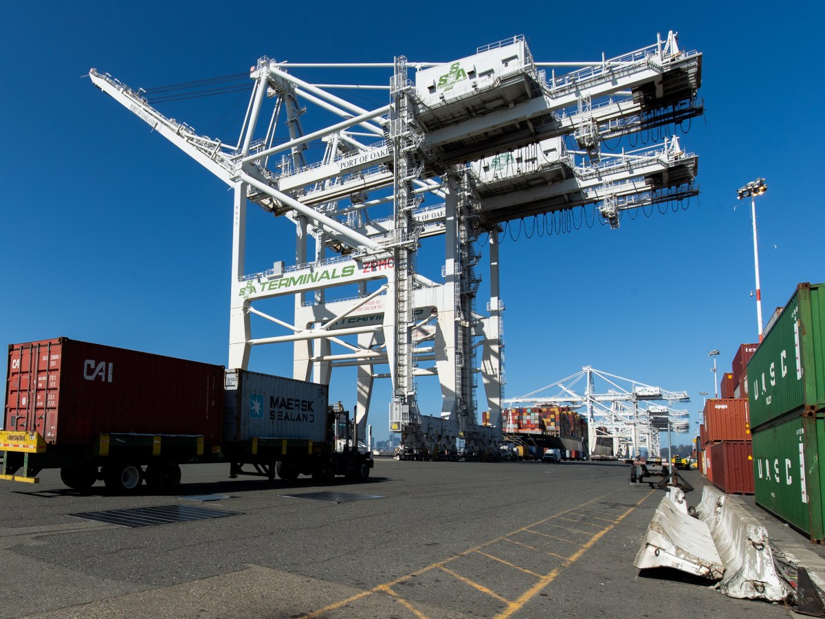 A big-rig truck hauls a shipping container at Howard Terminal.
