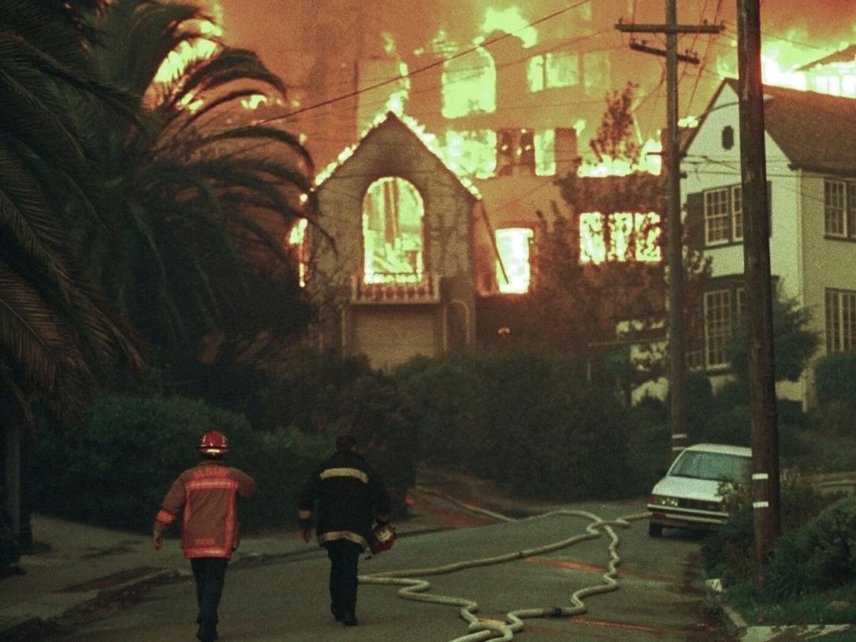 Firefighters walk up Rockridge Blvd. towards burning homes in Oakland, Calif., Oct. 20, 1991. A wind-driven brush fire exploded into a firestorm Sunday as it roared through residential neighborhoods in the hills above Oakland, engulfing hundreds of homes and killing 25 people. Credit: AP Photo/Olga Shalygin