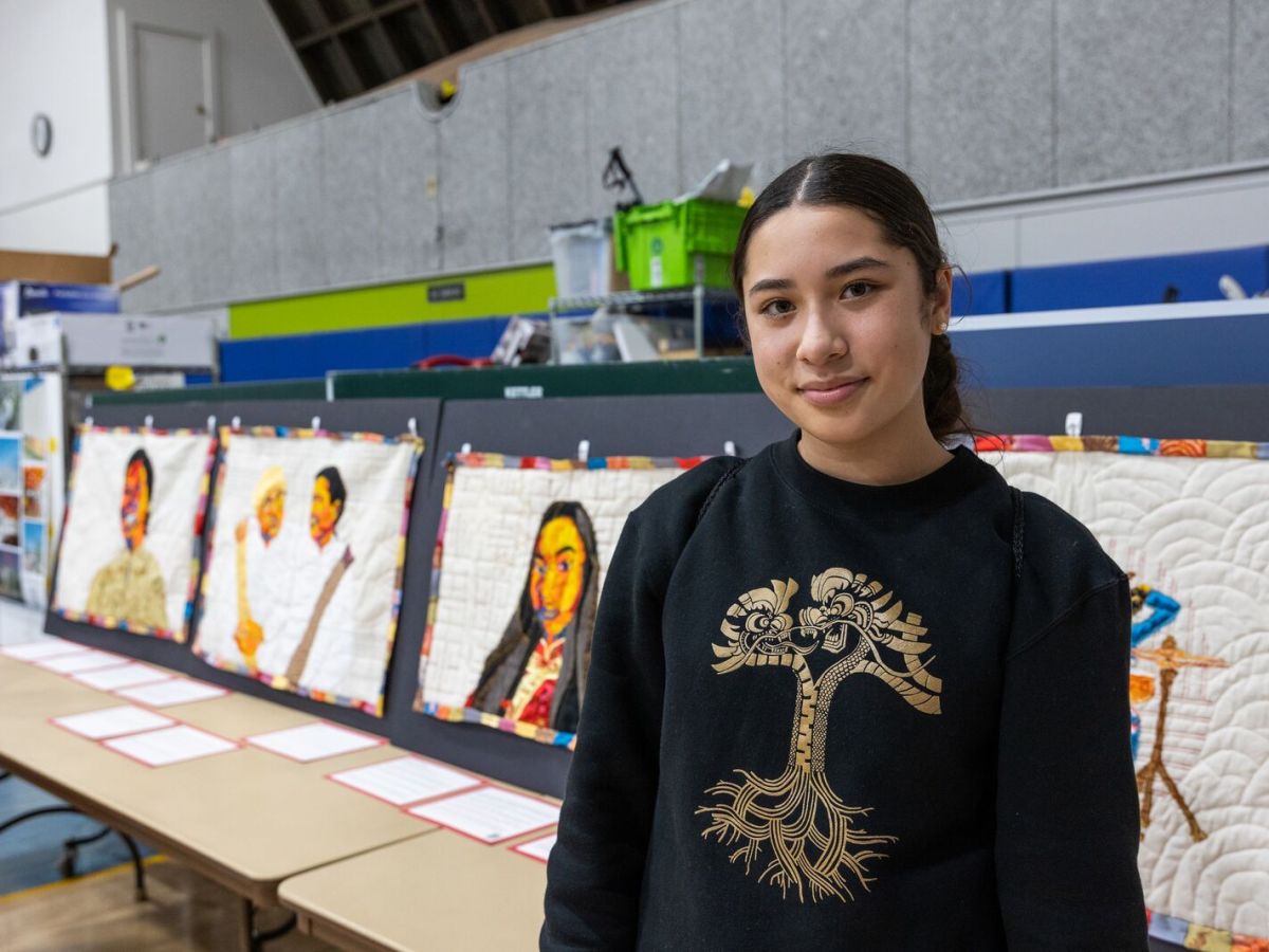 poinciana hung-hess stands in front of her senior art exhibit