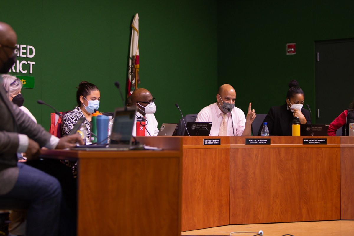 Oakland Unified school board members sitting behind the dais during a board meeting.
