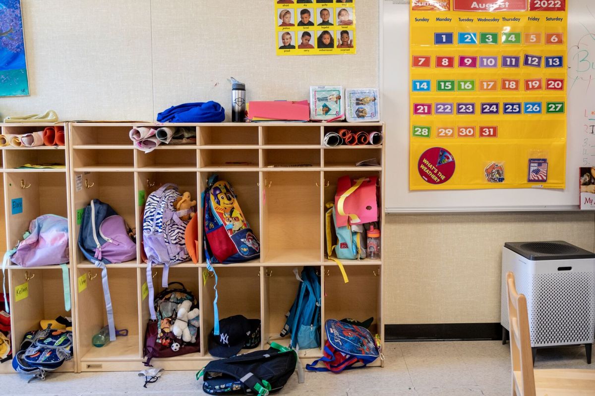 backpacks and lunchboxes and other belongings fill school shelves in a transitional kindergarten classroom