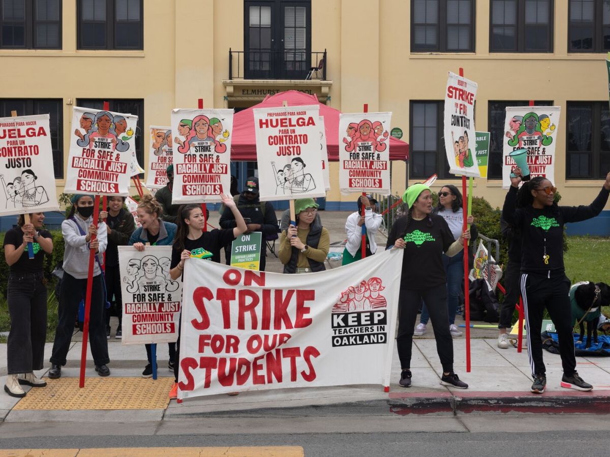 Striking Oakland teachers hold signs reading "Huelga!" and "Strike for our students!" on the picket line at Oakland Technical High School on Thursday, May 4, 2023.