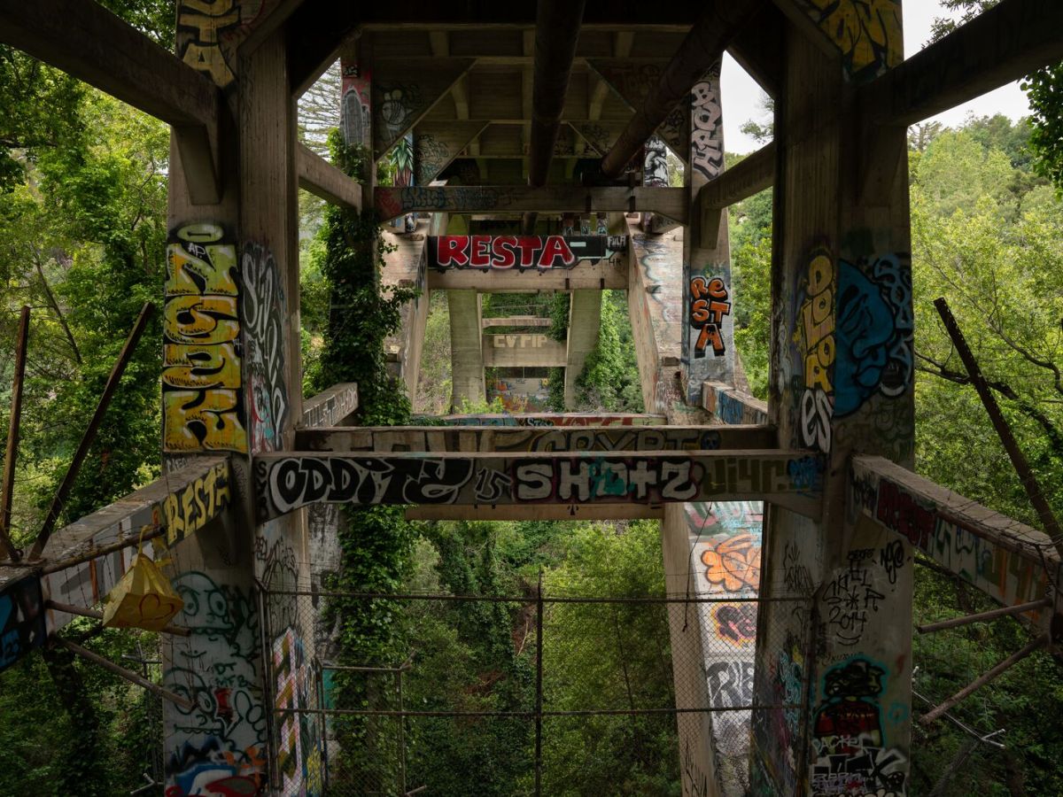 Graffiti adorns the underside of a bridge.