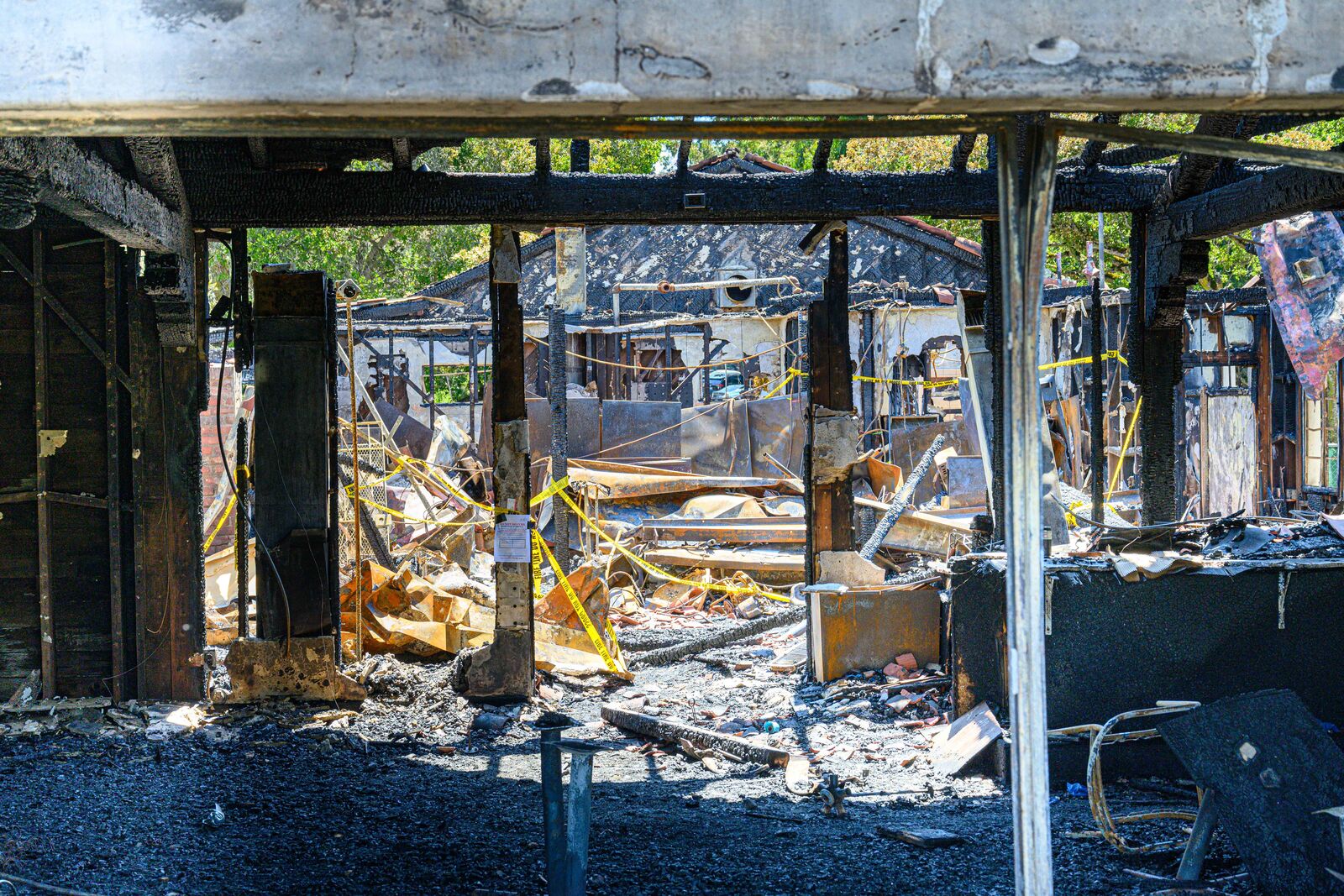Sunlight filters through a room that has been completely gutted by a fire.