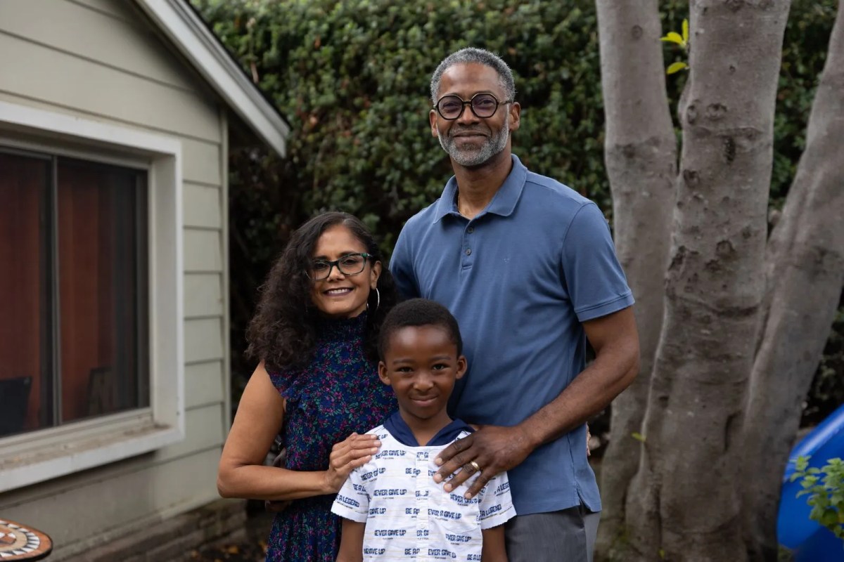 Parents Shefali Shah and Saleem Shakir-Gilmore with son Amari Shah-Shakir stand in front their home in Oakland, California.