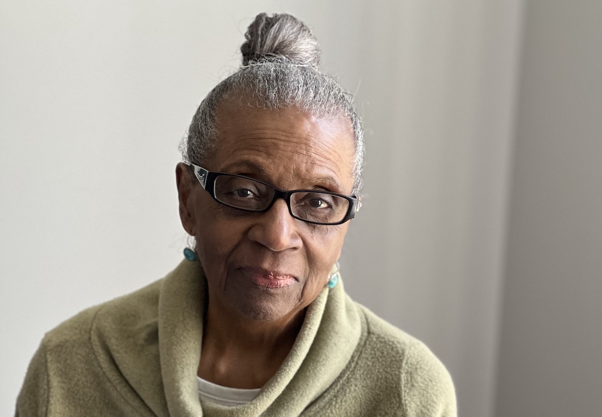 Older woman with a bun and glasses.