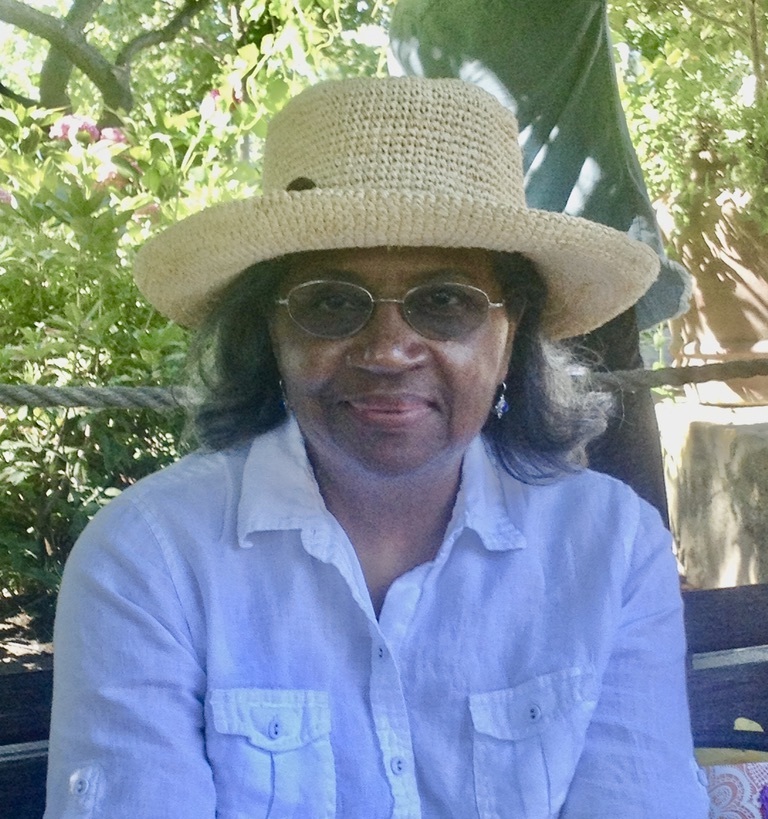 A smiling woman wearing a straw hat.