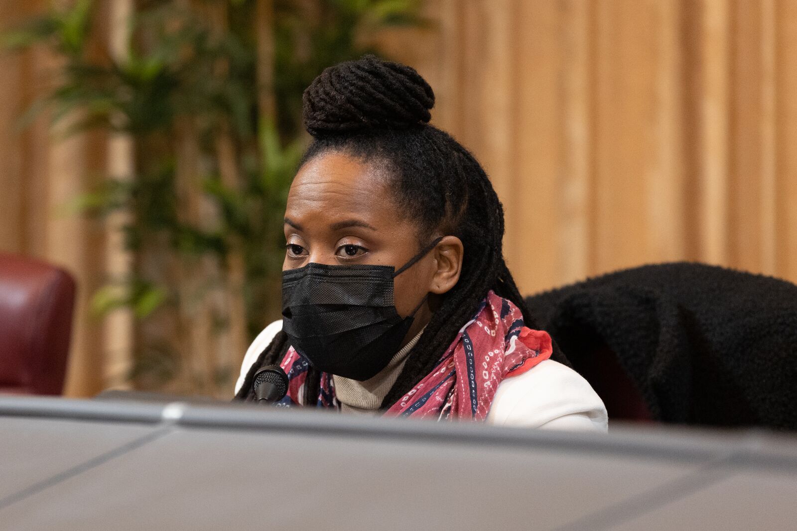 Oakland Councilmember Carroll Fife wearing a mask and speaking into a microphone in the council chambers.