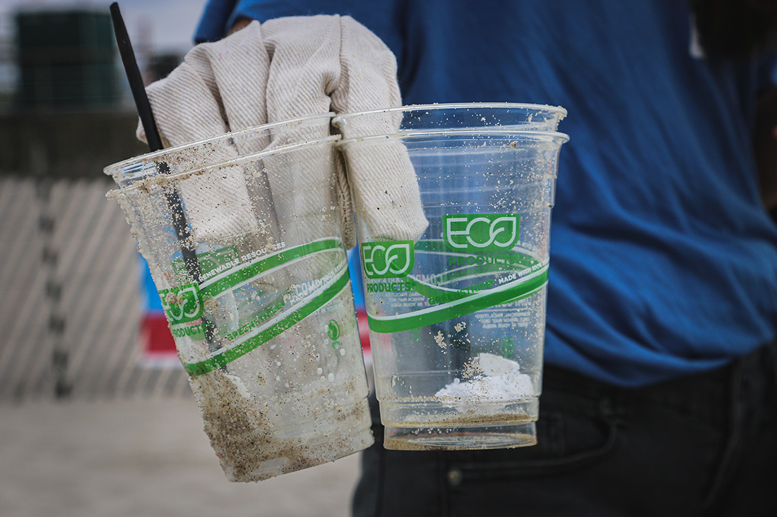 Two bioplastic cups in a gloved hand