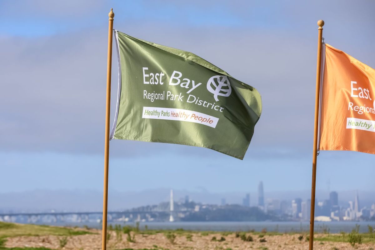 A green flag reading East Bay Regional Park District next to a orange flag